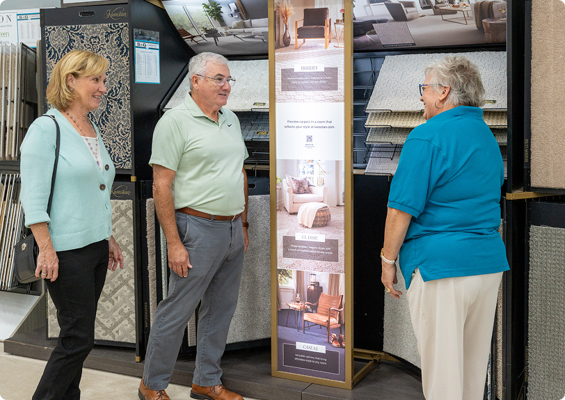 S&G Carpet associate helping a couple browse carpet samples in the showroom