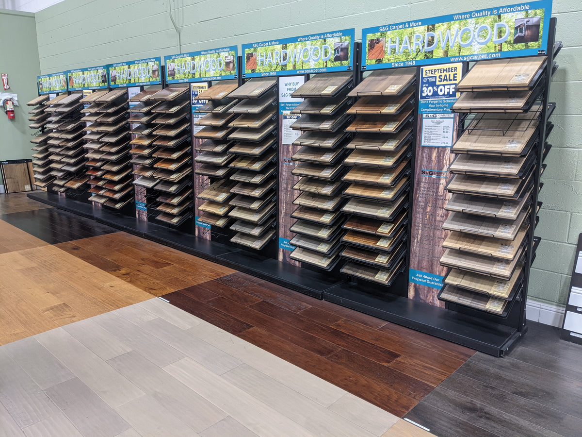 Hardwood flooring sample racks under Hardwood signs in the S&G Carpet showroom
