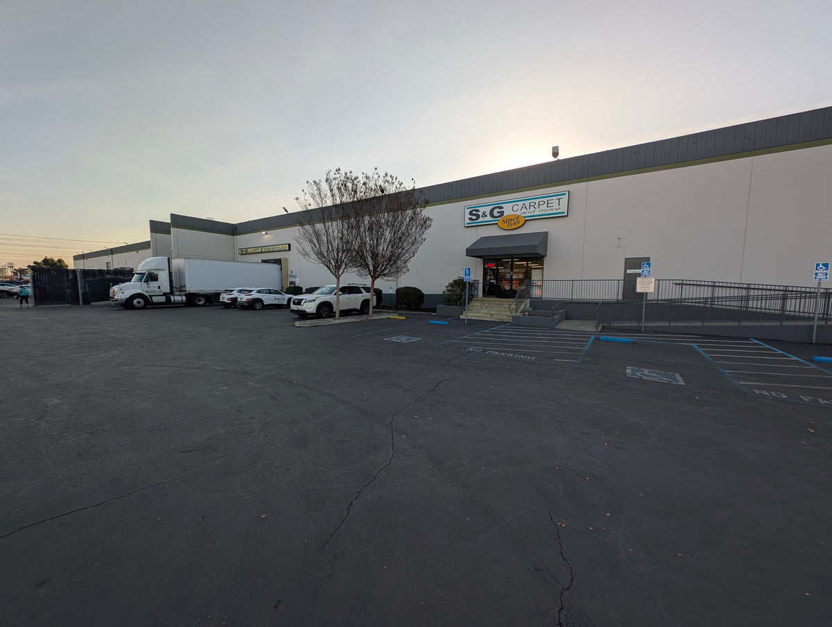 Exterior of an S&G Carpet and More storefront building and parking lot.