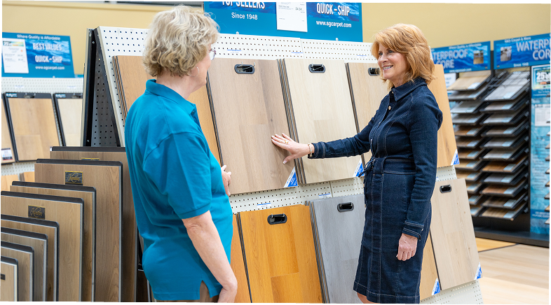 S&G Carpet associate and customer looking at wood-look plank samples in the showroom