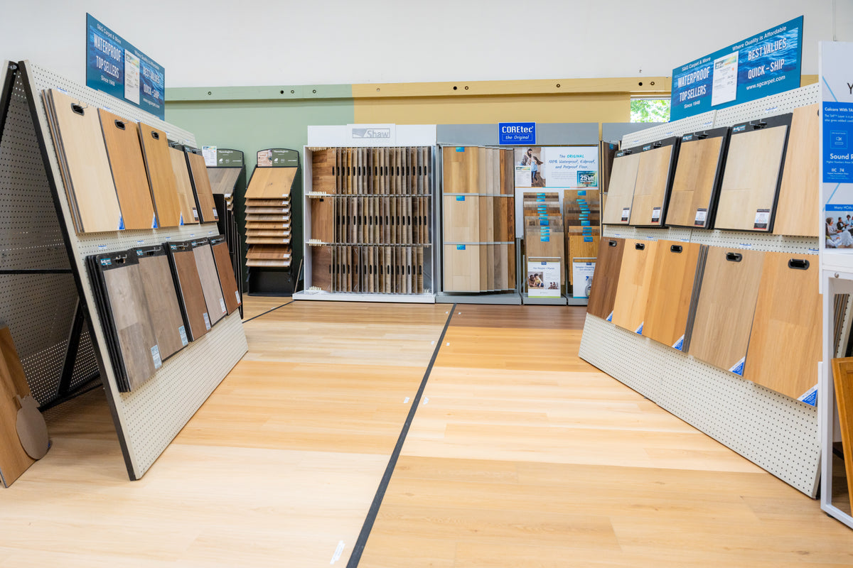 Showroom aisle at S&G Carpet lined with waterproof plank and hardwood sample displays