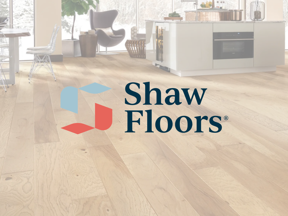 Shaw Floors logo over light oak hardwood flooring in a modern kitchen