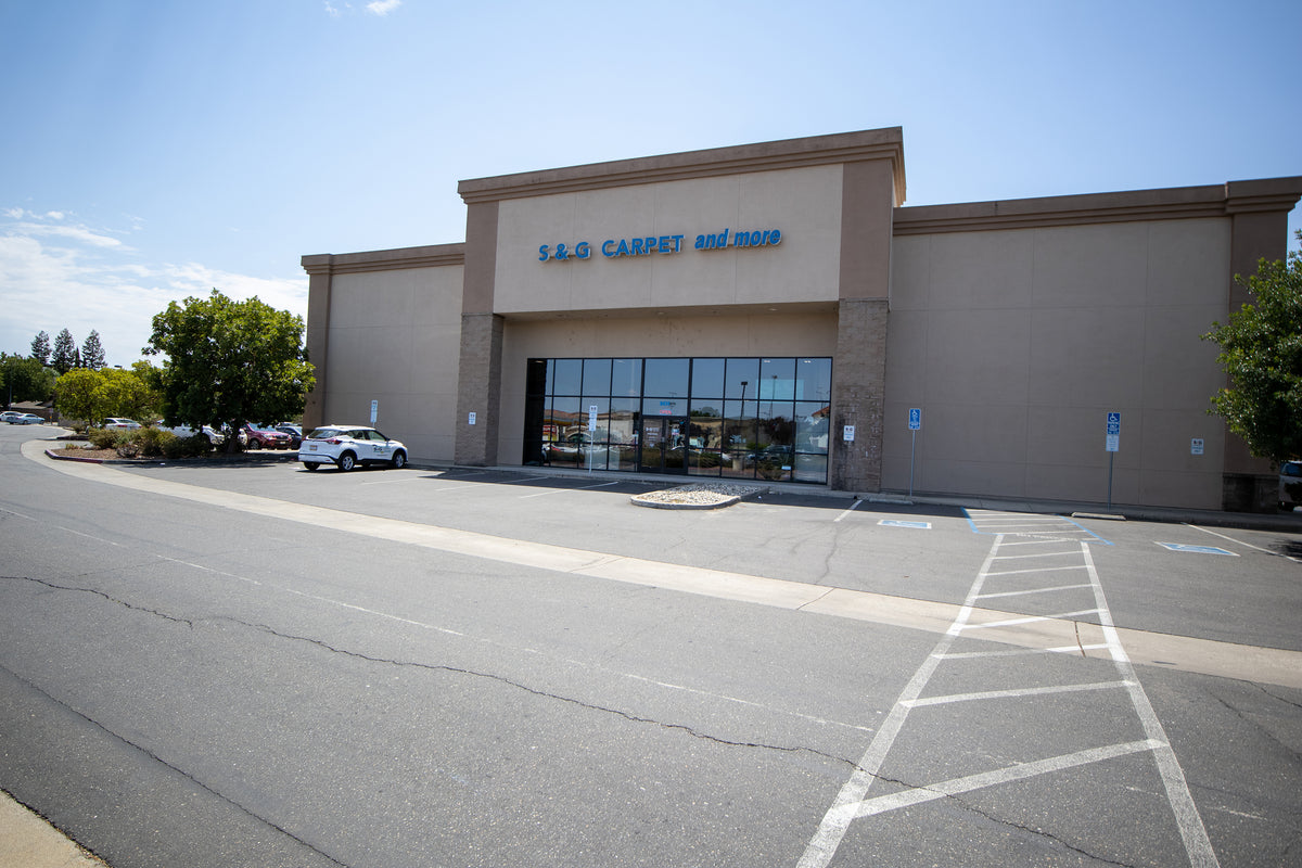 Beige single-story S&G Carpet flooring showroom exterior in Elk Grove with a large glass entrance