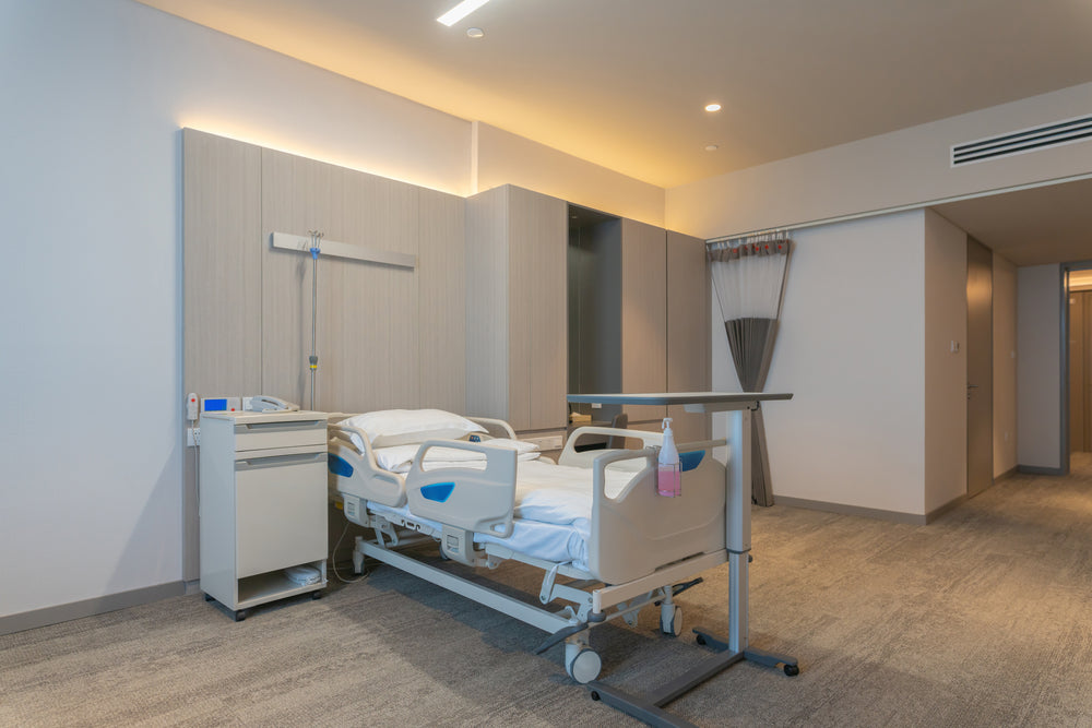 Beige commercial carpet in a modern hospital patient room with an adjustable bed